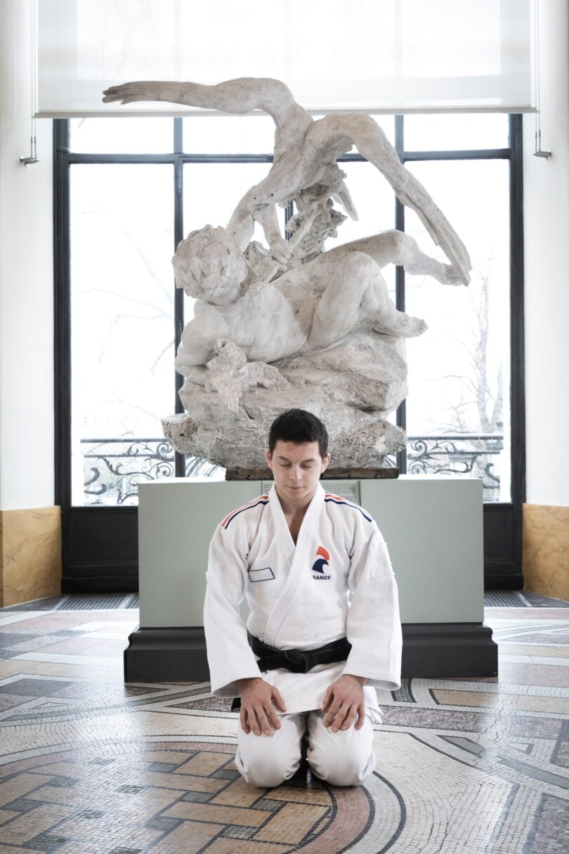 Der Judoka Romain Valadier-Picard vor Louis Gossins Skulptur „Le Dénicheur d’aigles“ (1890)